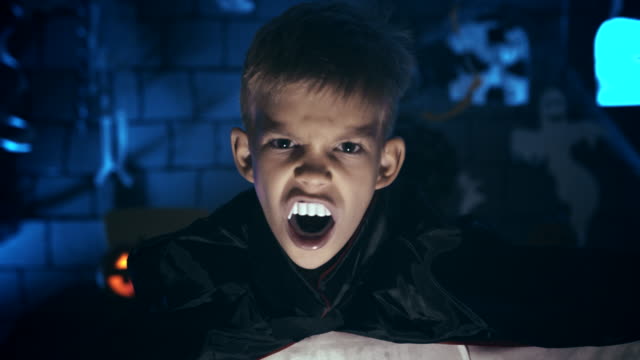 Young-boy-in-a-vampire-costume-for-Halloween-showing-his-scary-face-and-teeth-to-camera