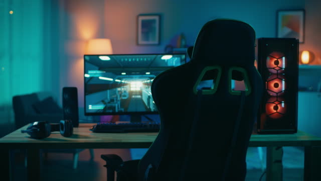Powerful-Personal-Computer-Gamer-Rig-with-First-Person-Shooter-Game-Paused-on-Screen.-Monitor-Stands-on-the-Table-at-Home.-Cozy-Room-with-Modern-Design-is-Lit-with-Warm-and-Neon-Light.