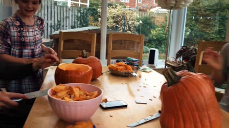 Happy-family-carving-pumpkins-for-a-Halloween-party