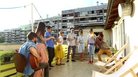 Happy-people-dancing-and-playing-guitar-at-the-rooftop-party-on-sunny-day
