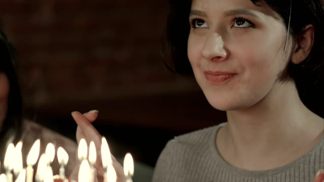Young-attractive-girl-is-about-to-make-a-wish-and-blow-all-candles