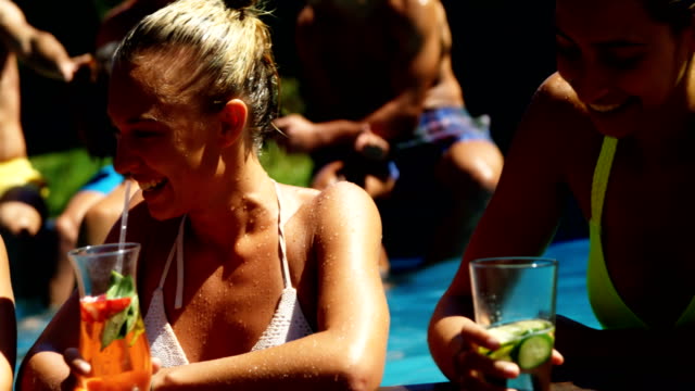 Sonriente-mujer-bebiendo-cócteles-y-divertirse-en-la-piscina