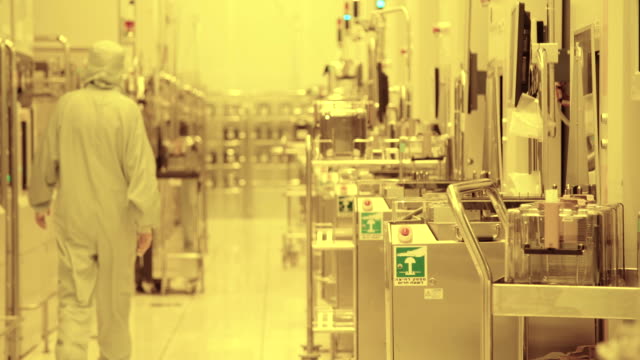 Trabajadores-de-trajes-limpiamos-en-un-planta-de-fabricación-del-Semiconductor