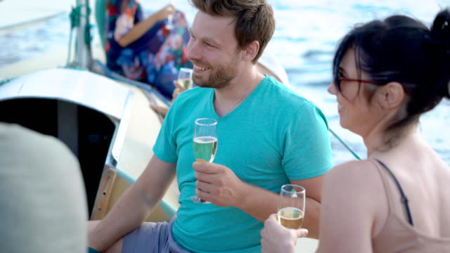 Junge-Freunde-genießen-Zeit-auf-Segelboot-mit-Party-mit-Champagner