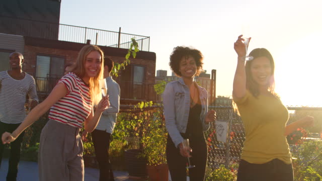 Junge-Erwachsene-Freunde-tanzen-auf-einer-Party-auf-einem-Dach-in-Brooklyn