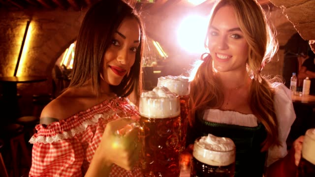 Beautiful-multi-ethnic-women-holding-beer-mugs-at-Oktoberfest-festival-celebration