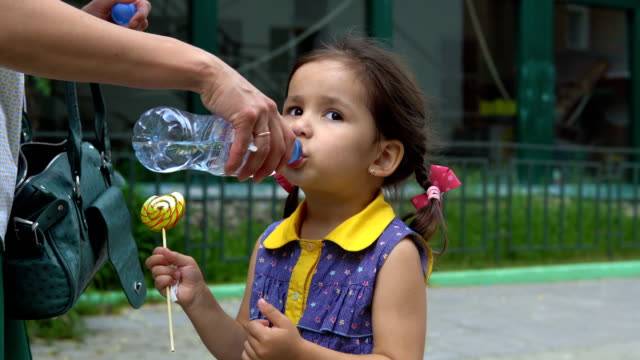 Ein-kleines-Mädchen-trinkt-aus-einer-Plastikflasche.