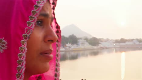 Husband-and-wife-talking-against-the-beautiful-sunset-at-Pushkar-Lake,-India,-handheld