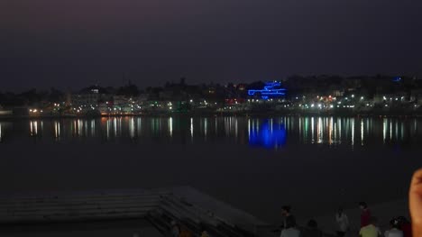 Retrato-de-una-pareja-India-contra-el-fondo-de-luces-sobre-el-lago-sagrado-de-Pushkar,-Rajastán
