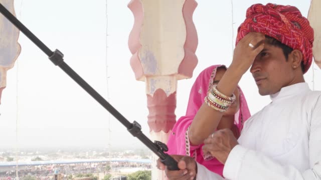 Attraktive-indische-Paare-im-traditionellen-Kleid,-immer-bereit-und-nehmen-Sie-Selfies-auf-ihrer-Handy-Kamera-in-Rajasthan,-Indien