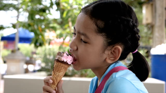 Zeitlupe-kleine-Asiatin-ist-Eis-essen-mit-Freude