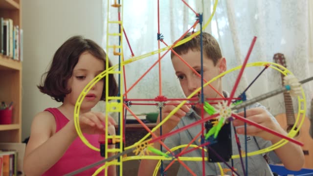 Jungen-und-Mädchen-bauen-einen-Turm-aus-Spielzeug-zu-Hause