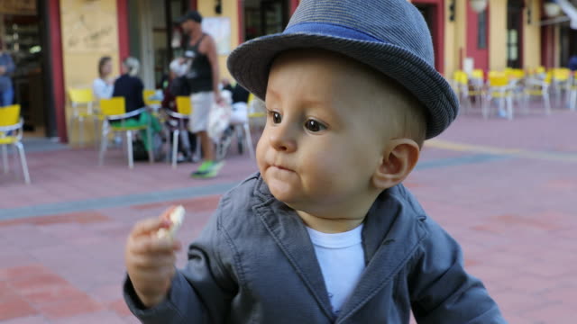 Niño-lindo-con-su-sombrero-italiano-comiendo-un-pastel-de-arroz