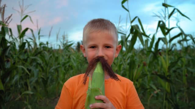 A-boy-with-corn-silk-mustache.-Boy-making-a-mustache-from-corn-hair