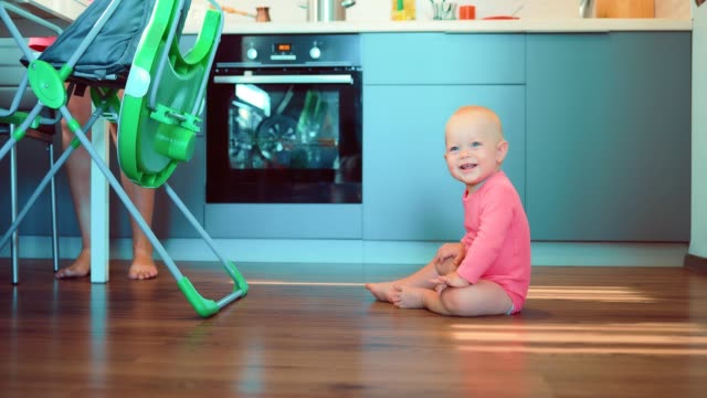 Kleines-Kind-sitzt-auf-dem-Boden-in-der-Küche