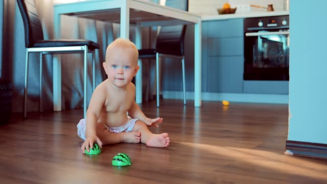 Cute-smiling-girl-playing-on-the-floor-with-toys-and-then-crawling-on-the-floor