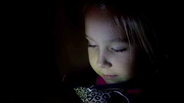 Kleine-Mädchen-spielen-Tablet,-Handy-in-der-Nacht,-Nahaufnahme