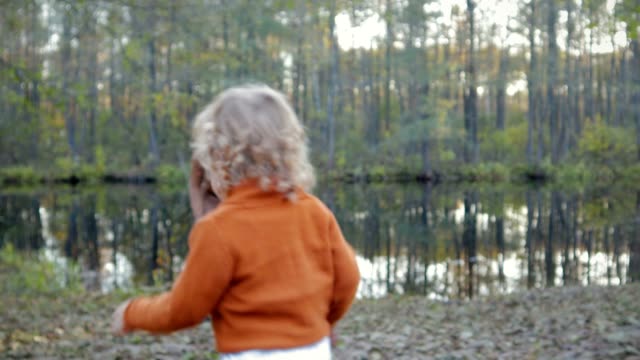 Glücklich-kleiner-Junge-läuft-am-See-im-Herbst-Park