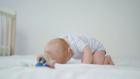 Lindo-bebé-gateando-sobre-la-cama-en-casa