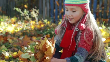 Schöne,-kleine-Mädchen-spielen-mit-Herbst,-gelbe-Blätter-im-Park.-Das-Konzept-des-Herbstes