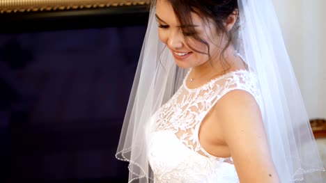 close-up,-bride-fees.-the-bride-is-dressed-for-the-wedding.-portrait-of-a-beautiful,-smiling-bride,-in-veil-and-lace-dress.-Bridesmaid-laces-up-white-lace-dress-with-ribbon.-Wedding-dress-details