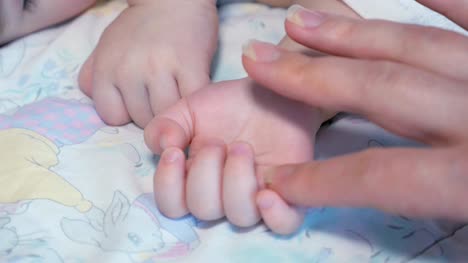 Mutter-streicheln-schlafendes-Baby-Hand