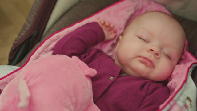 Schlafendes-Baby-mit-Spielzeug-dreht-ihren-Kopf