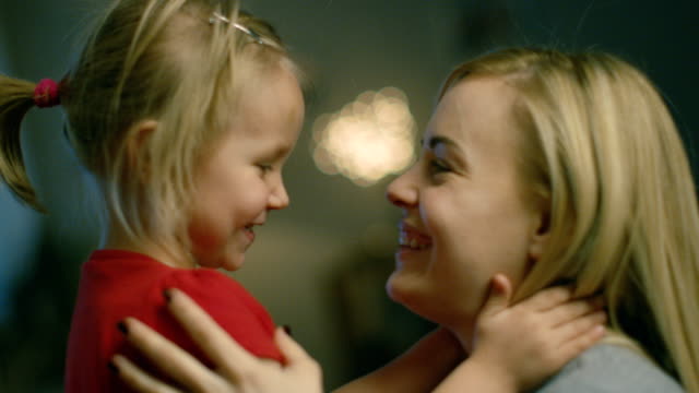 Close-up-Shot-of-a-Beautiful-Mother-Holding-Her-Cute-Blonde-Daughter-and-Smiling.