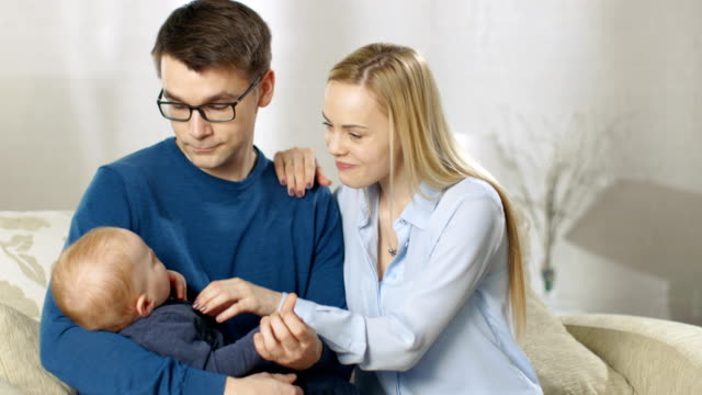 Happy-Family.-Father-Lovingly-Holds-His-Little-Baby-Then-Gives-it-to-His-Wife.