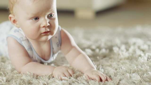 Tiro-de-cerca-de-un-pequeño-bebé-lindo-arrastrándose-en-una-alfombra.