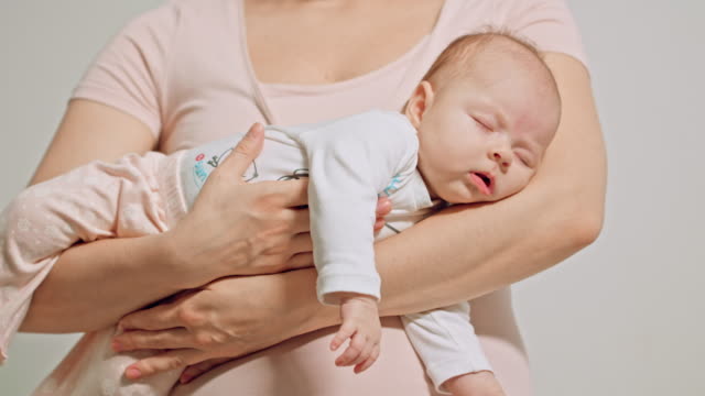 Bebé-en-brazos-de-las-madres-quedarse-dormido