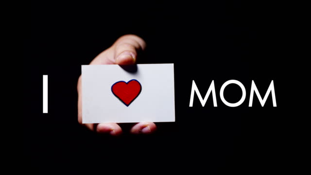 Eine-Hand-zeigt-eine-romantische-Karte-sagen-\"I-love-Mama\".-Konzept:-Liebe,-helfen-Sie-anderen,-wie,-Liebe-für-die-Familie,-für-seine-Mutter,-dank-seiner-Mutter-für-alles,-was-sie-für-die-Kinder-tut