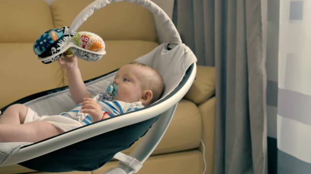 Cute-little-baby-with-dummy-is-rocking-by-the-modern-cradle