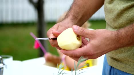 Sommer-im-Garten,-Zeitlupe,-close-up,-Männerhände,-einen-Apfel-mit-einem-Messer-schälen,-schneiden-Sie-die-Schale