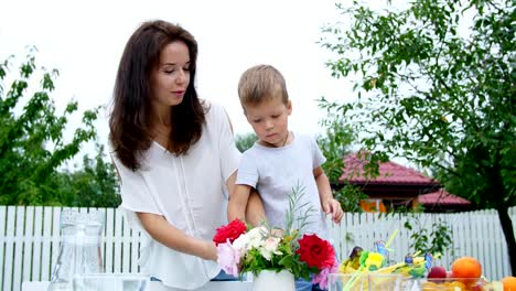 summer,-in-the-garden.-Mom-with-a-four-year-old-son-make-a-bouquet-of-flowers.-The-boy-likes-it-very-much,-he-is-happy,-having-fun,-The-family-spends-their-leisure-time-together