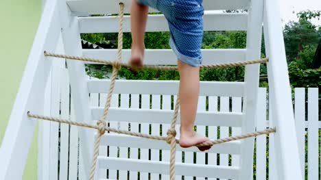 summer,-in-the-garden,-child,-a-four-year-old-boy-climbs-the-children's-stairs-on-the-playground.-The-family-spends-their-leisure-time-together