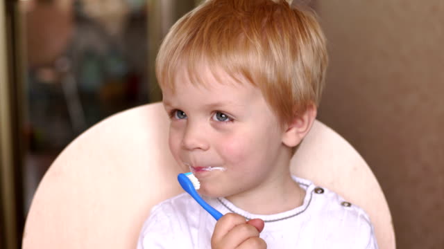 Little-boy-brushing-his-teeth-himself,-close-up.4K