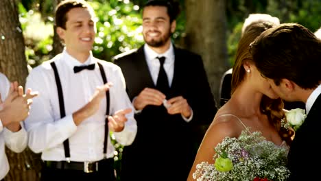Braut-und-Bräutigam-küssen-einander-und-Gäste-klatschten-im-Hintergrund-4K-4k