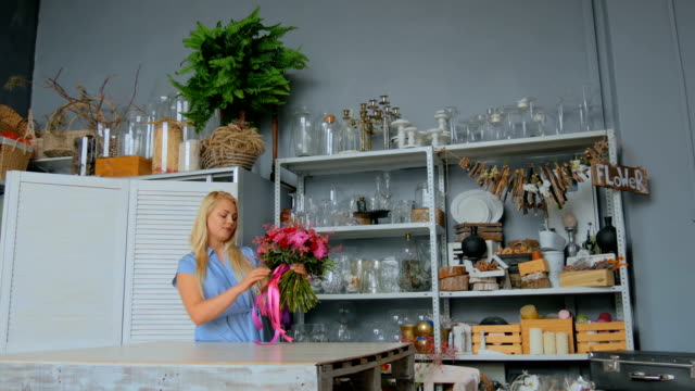 Professional-florist-holding-and-checking-bouquet-at-studio