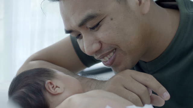 4K-lenta-feliz-asiático-padre-cuidar-a-su-hija-del-bebé-recién-nacido-en-casa