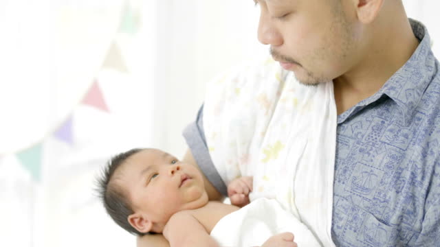 4K-lenta-feliz-asiático-padre-cuidar-a-su-bebé-recién-nacido