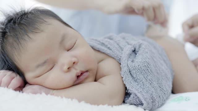 4K-Slow-motion-shot-of-Asian-parents-take-care-newborn-baby