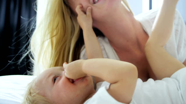 Porträt-der-Mutter-küssen-ihr-Babymädchen-indoor