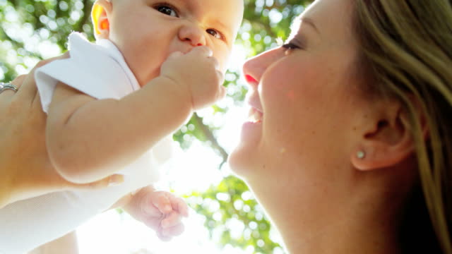 Portrait-of-Caucasian-mother-outdoors-kissing-baby-boy