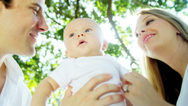 Portrait-of-Caucasian-parents-with-baby-girl-outdoors