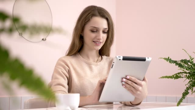 Elegant-beautiful-caucasian-woman-using-tablet-computer,-texting,-typing.-Smiling-in-cafe-60-fps