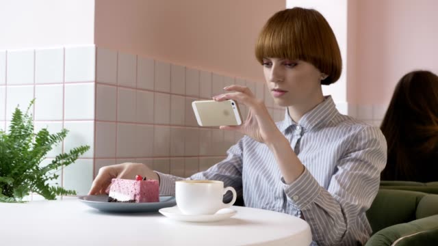 Junge-schöne-rothaarige-Mädchen-Foto-Kuchen-im-Café-sitzen-zu-tun.-Problem-heute,-soziales-Netzwerk.-60fps
