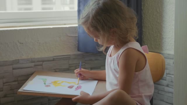 Child-girl-drawing-by-watercolor-at-home-in-slow-motion.