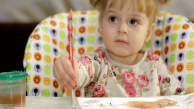 Schöne-zwei-Jahre-alt-Mädchen-zeichnet-Bilder-mit-einem-Pinsel.-Cute-blonde-Kind.-Braune-Augen.-Nahaufnahme