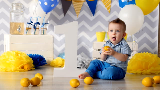 The-boy-is-playing-with-the-lemon.-He-is-trying-to-taste-it.